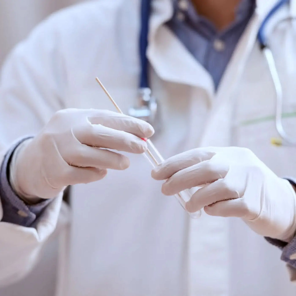 Klare glasröhrchen mit rotem gummistopfen in hygienstar safe premium weiße nitrilhandschuhe in medizinischer umgebung