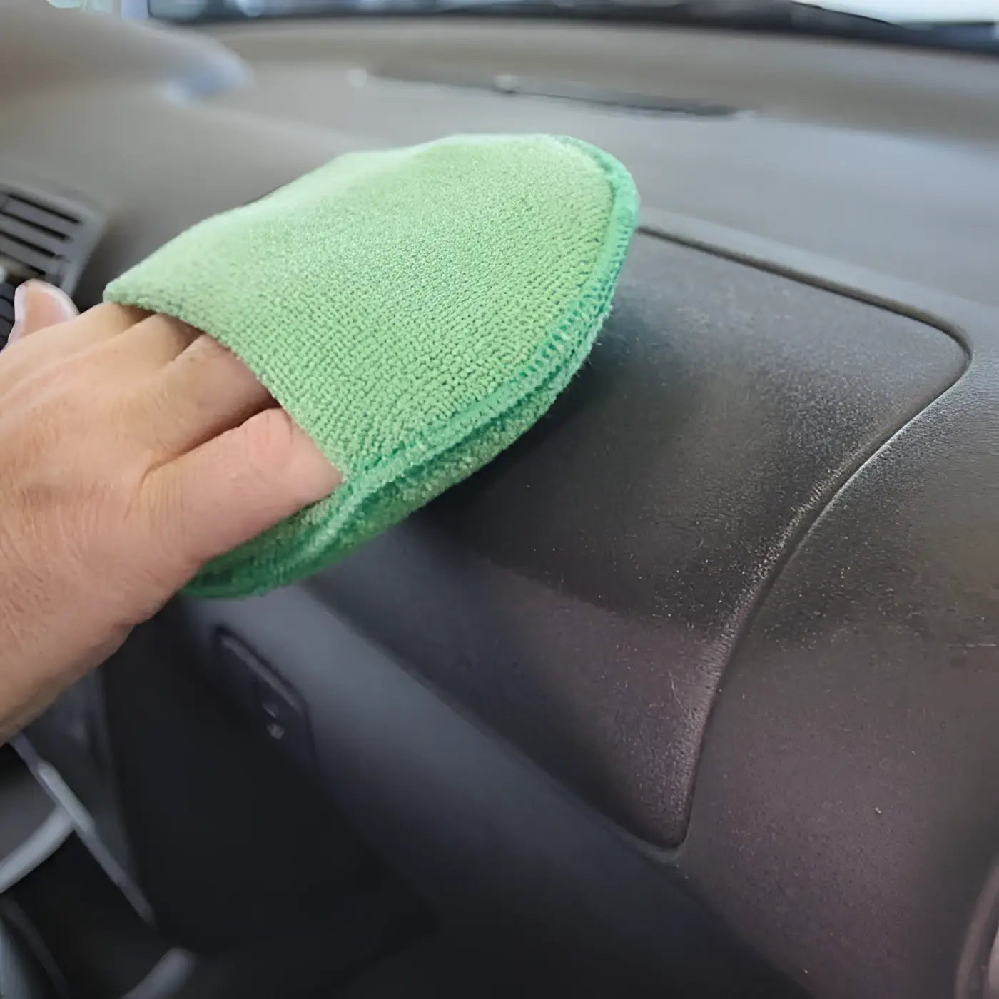 Grünes mikrofaser-reinigungstuch für armaturenbrett mit sonax cockpitpfleger 400ml zur pflege von fahrzeuginnenräumen