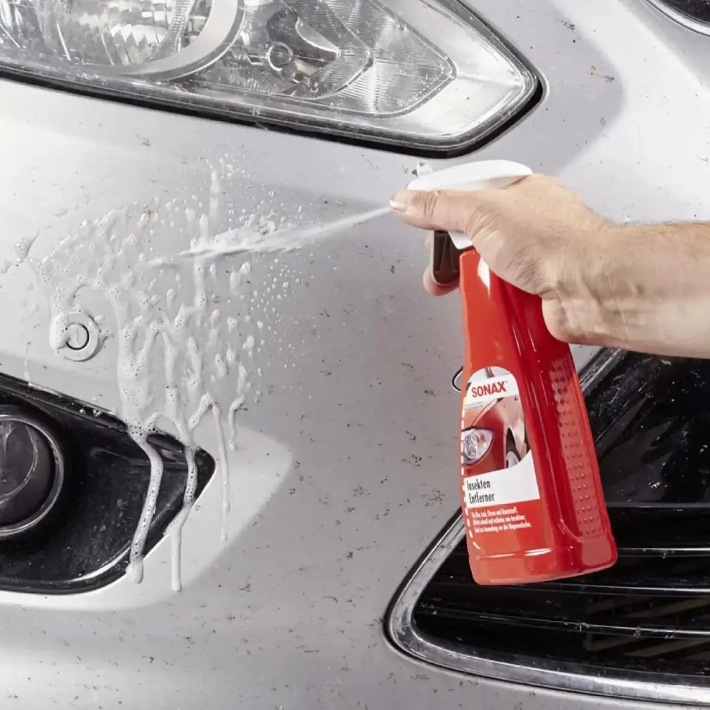 Rotes sonax insektenentferner 500ml sprayflasche mit weißer düse zur reinigung von fahrzeugoberflächen