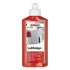 Rote plastikflasche mit weißem pumpspender sonax lackreiniger mit schleifmittel zur autolackpflege