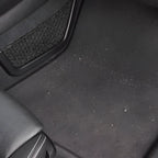 Schwarze strukturierte auto fußmatte mit integriertem mesh aufbewahrungsfach zum sonax xtreme autoinnenreiniger 500ml