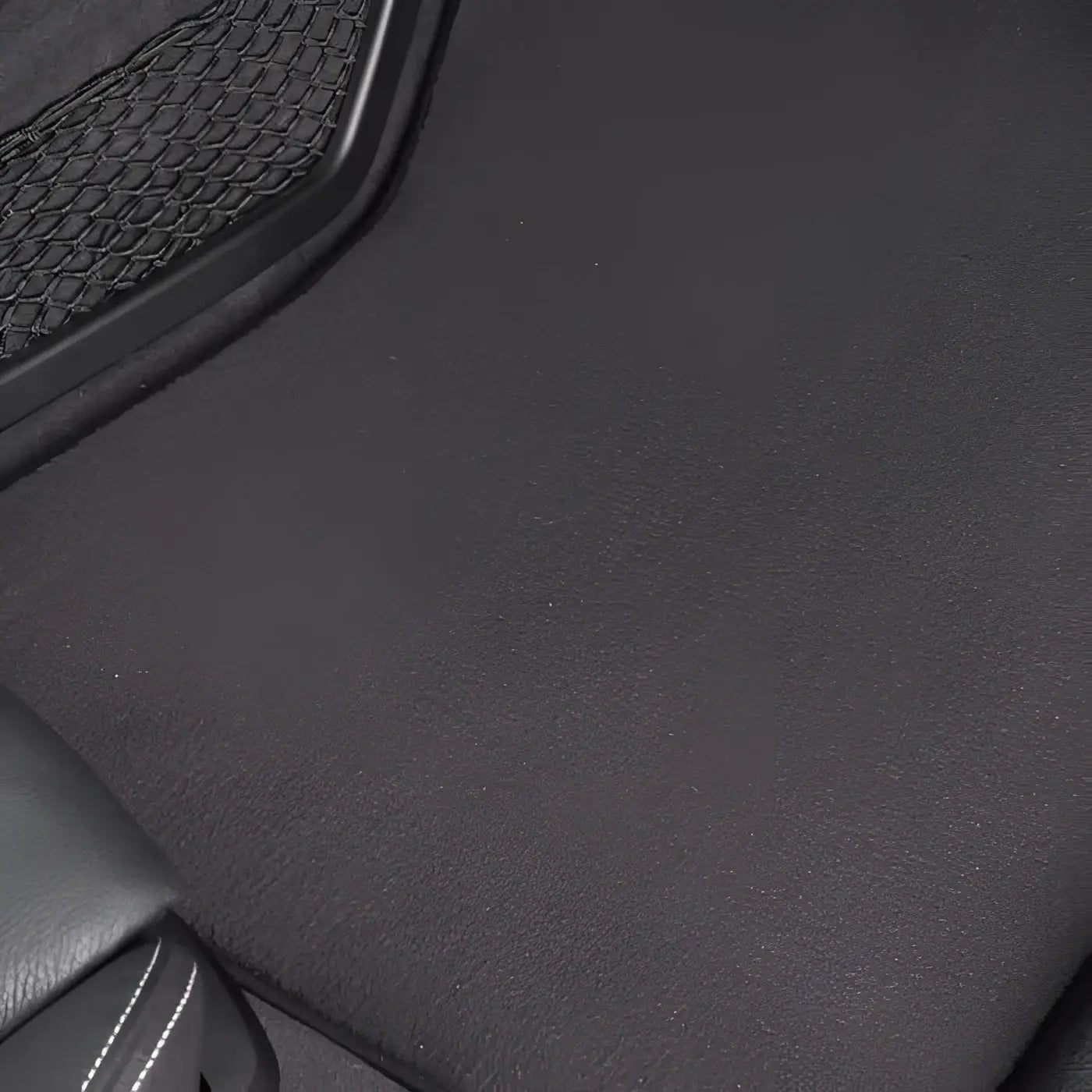Schwarze strukturierte autofußmatte mit mesh-tasche am rand passend für sonax xtreme autoinnenreiniger 500ml