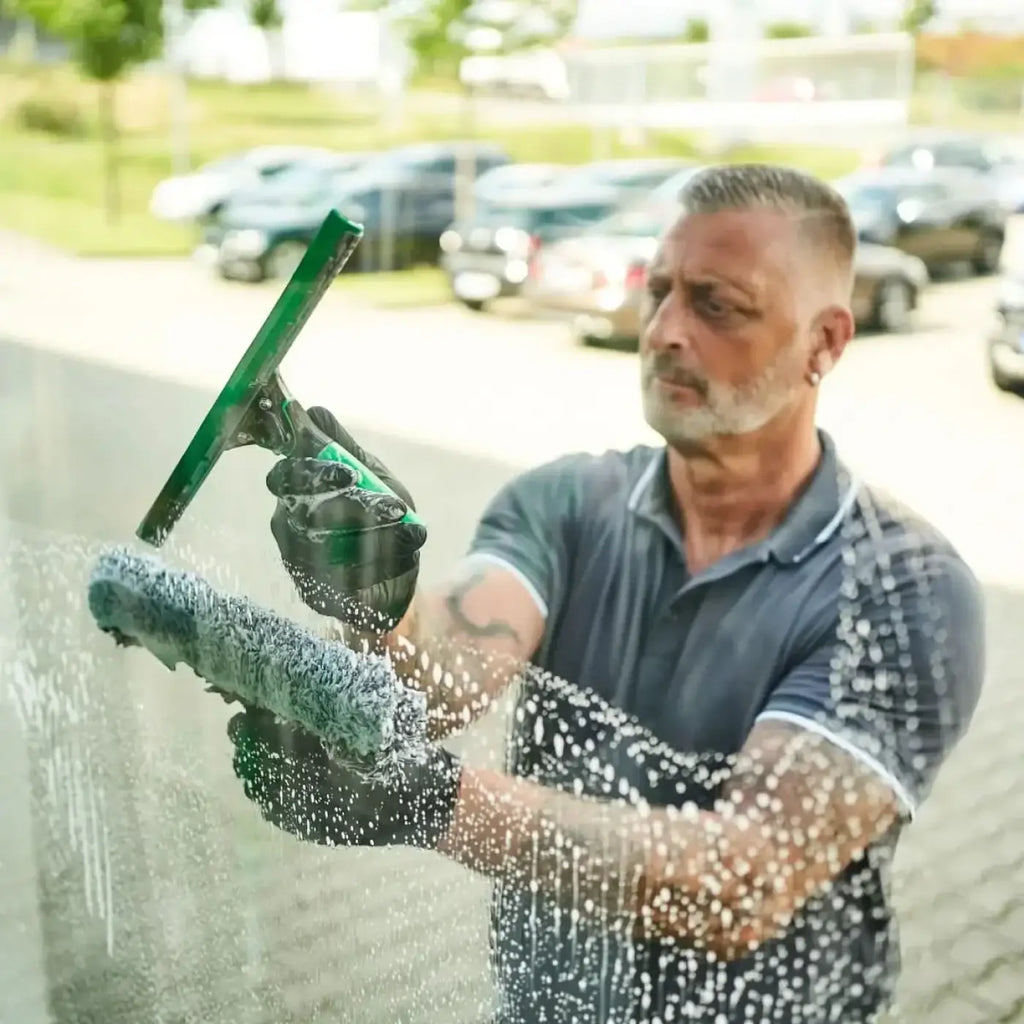 Grüner squeegee mit schwarzem griff und strukturiertem gummilippe im unger ergotec profi glasreinigungsset ak013