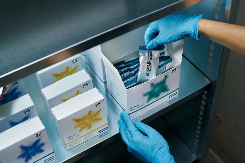 Wetrok granufloor bodenreiniger sticks in blauer und weißer verpackung mit grünem sternchendesign